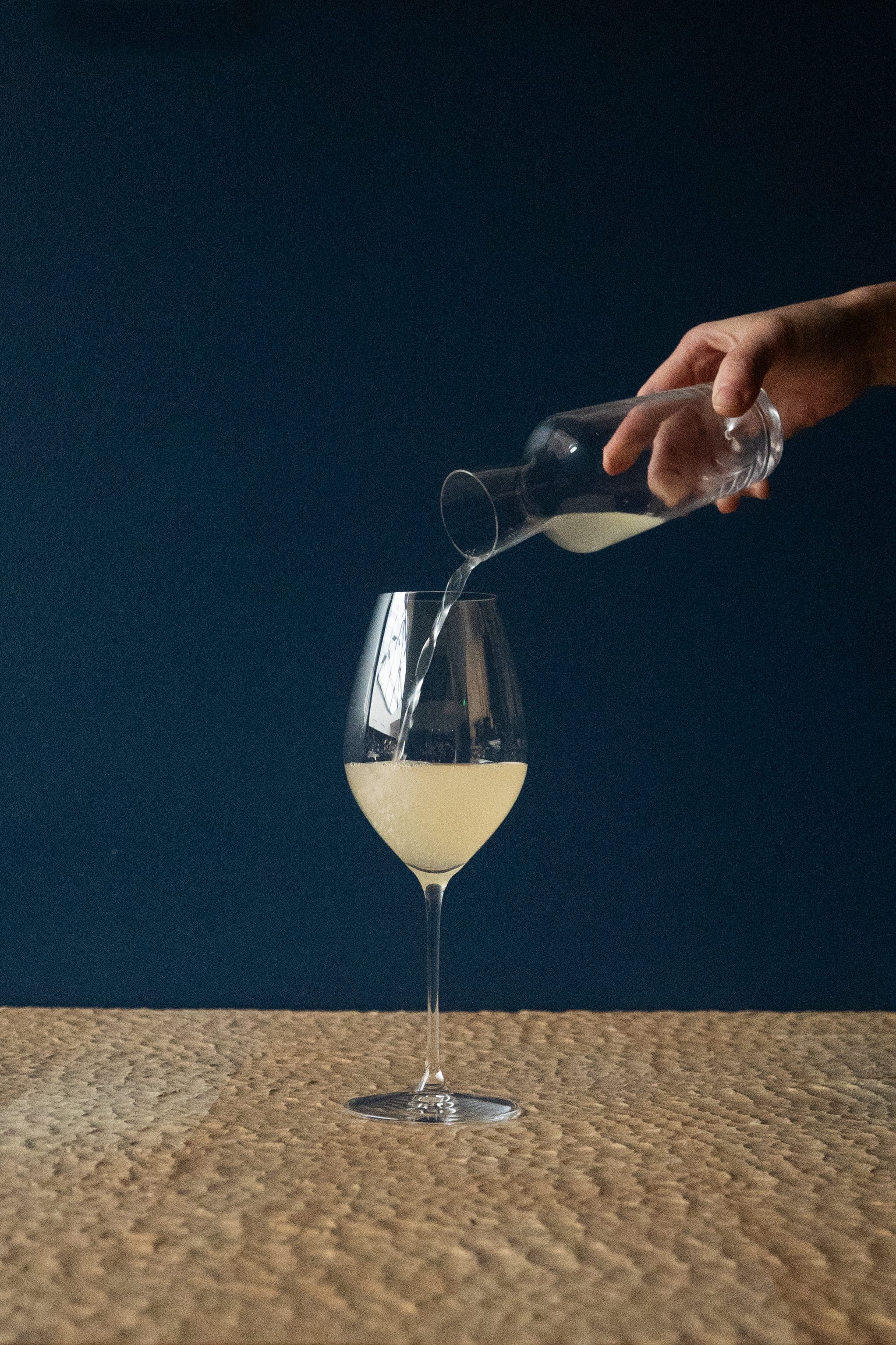 Service d'un saké versé dans un verre à pied