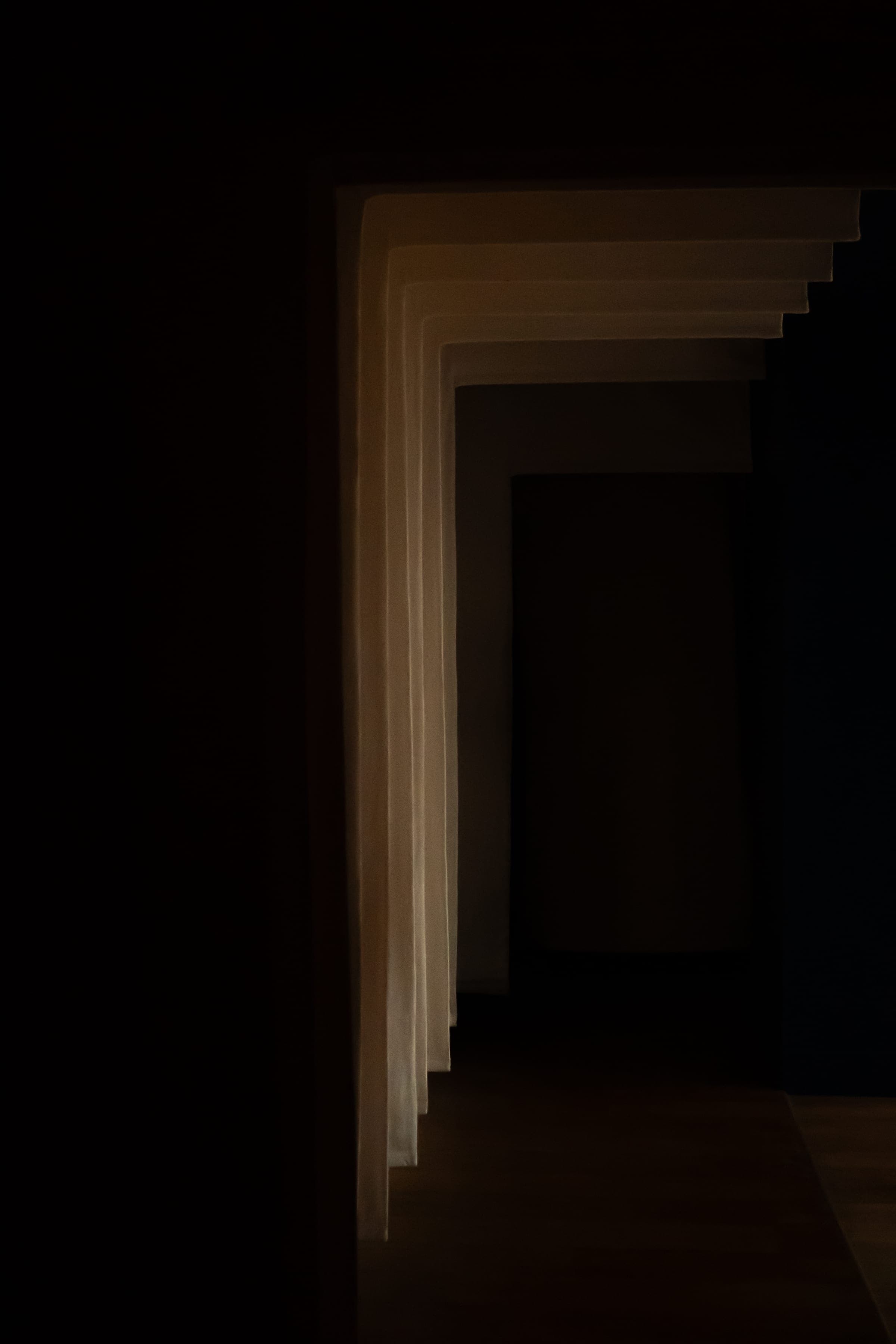 Enfilade de portes voûtées dans un couloir sombre, jeu de lumière